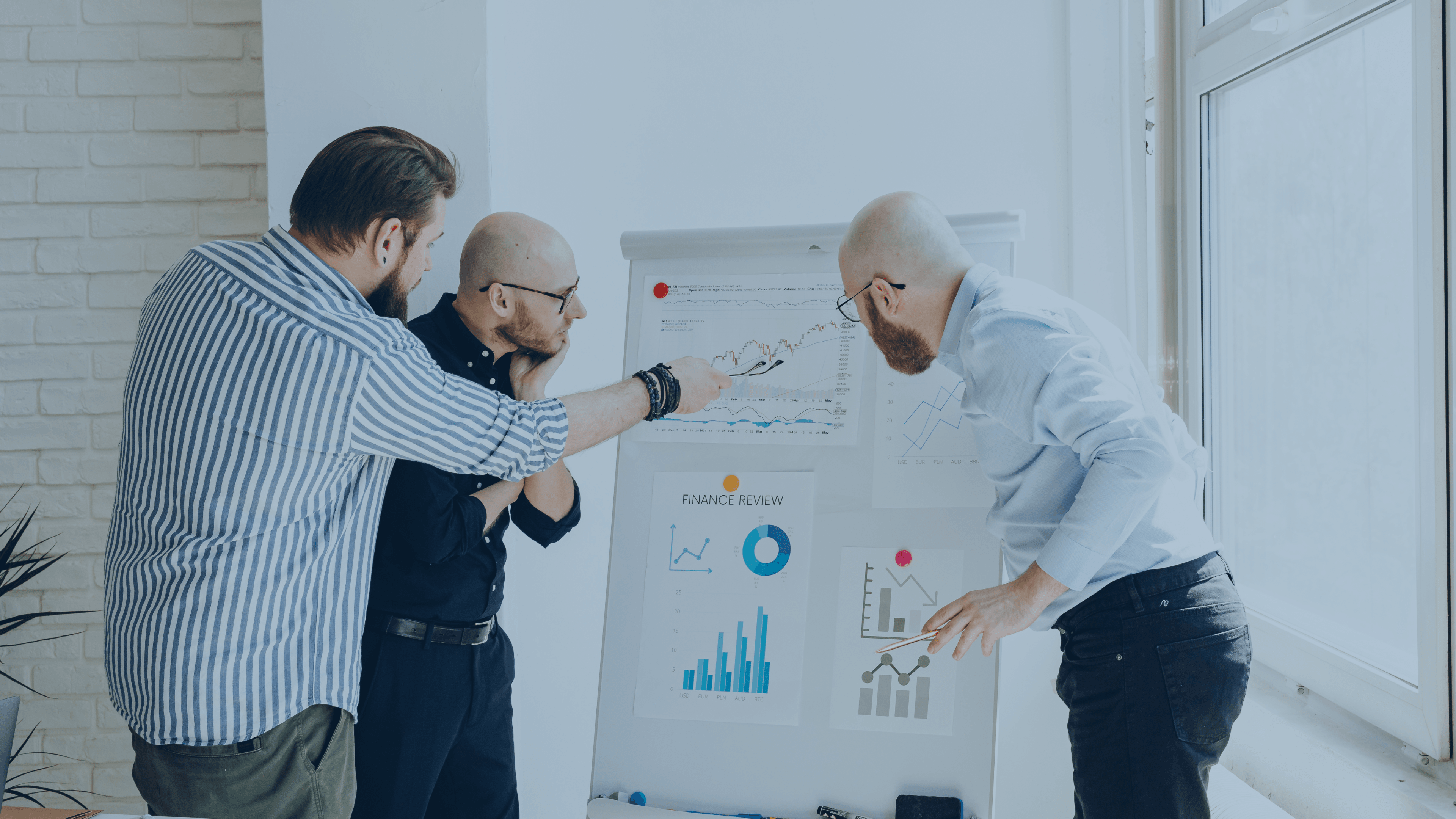 Ledelsesteam analyserer KPI’er, budgettal og performancegrafer på whiteboard under finansielt reviewmøde.